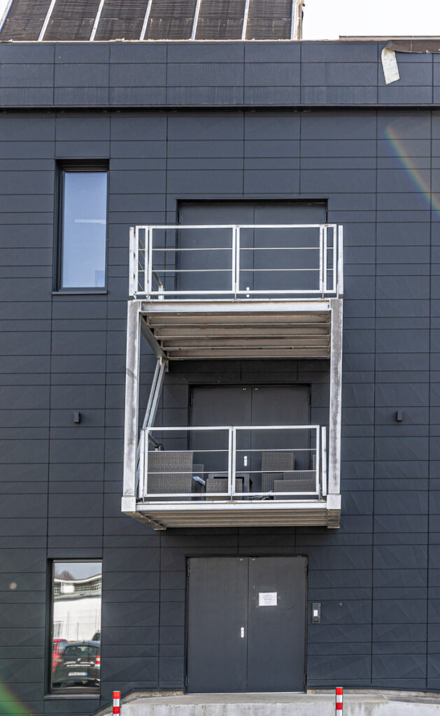 Ein gleichzeitig als Überdachung und Balkon fungierender Anbau an ein Industriegebäude